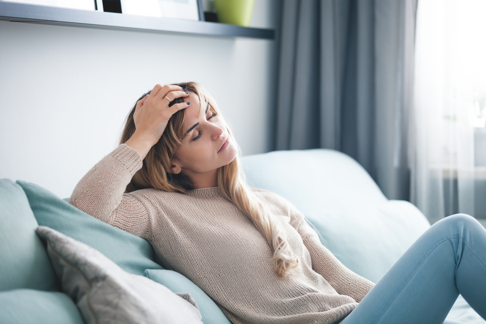 woman sitting on couch very tired