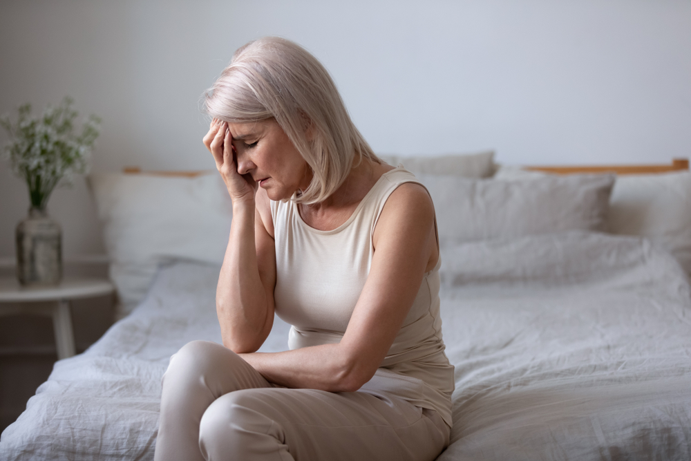 middle aged woman touching face due to challenging hormone imbalance symptoms