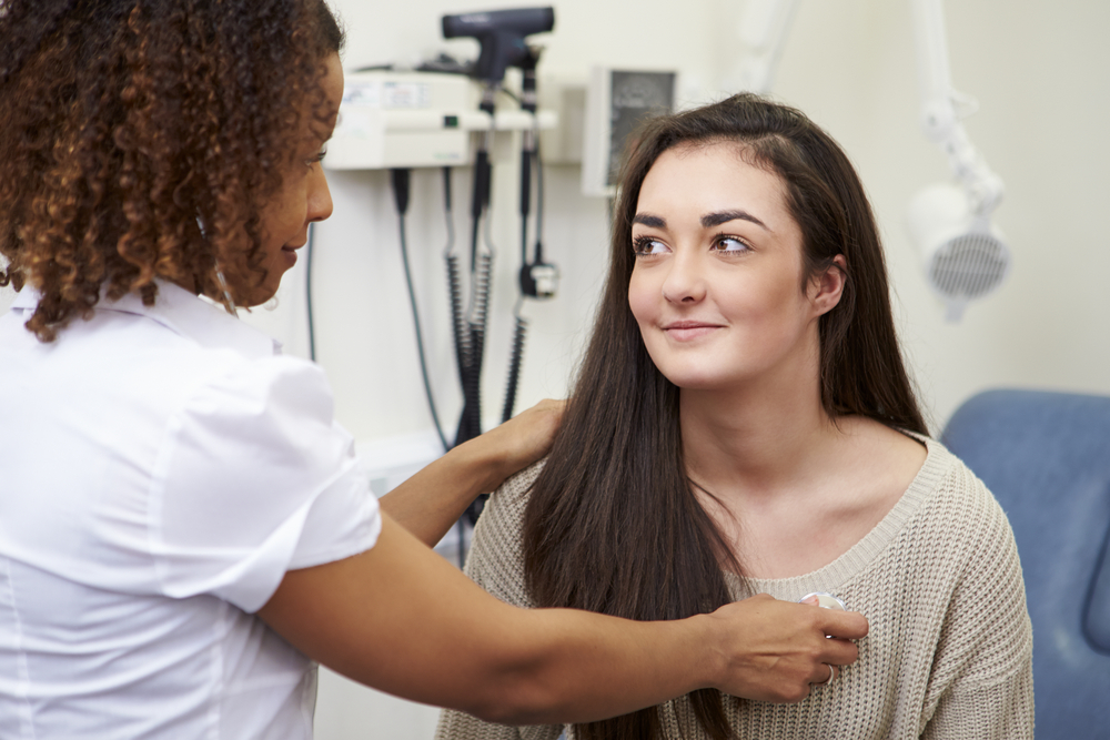 nurse taking teen patient's vitals during doctor visit