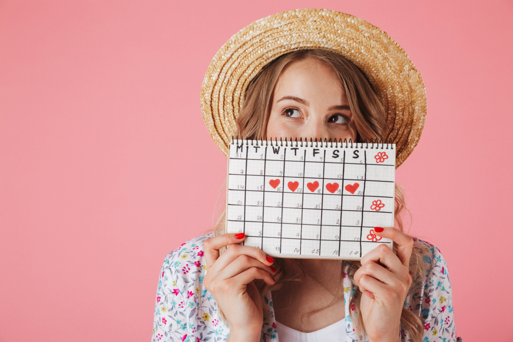 woman holding calendar tracking menstrual cycle