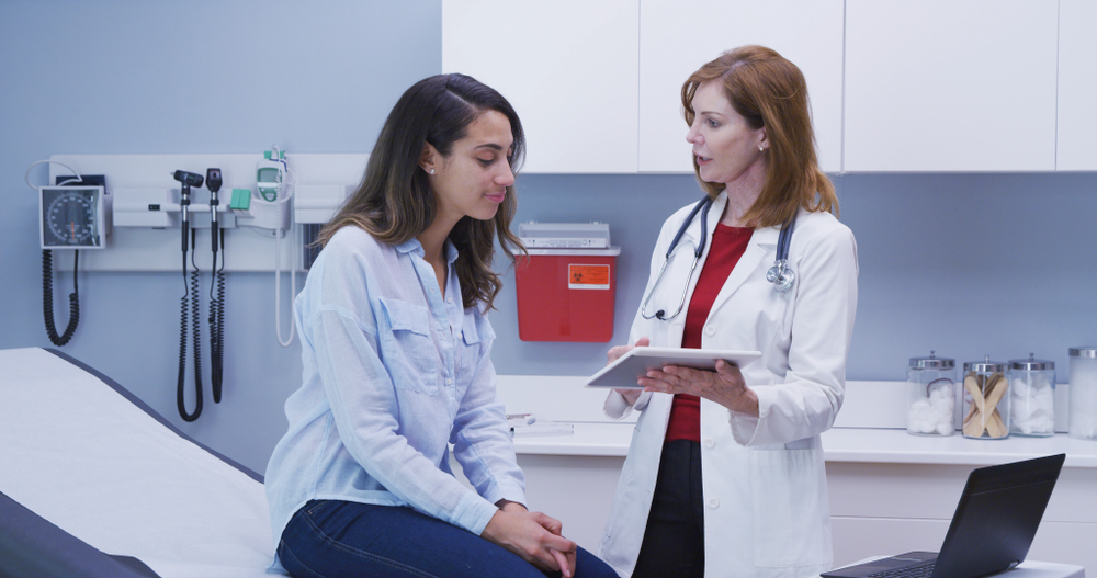 Young woman talking to her doctor