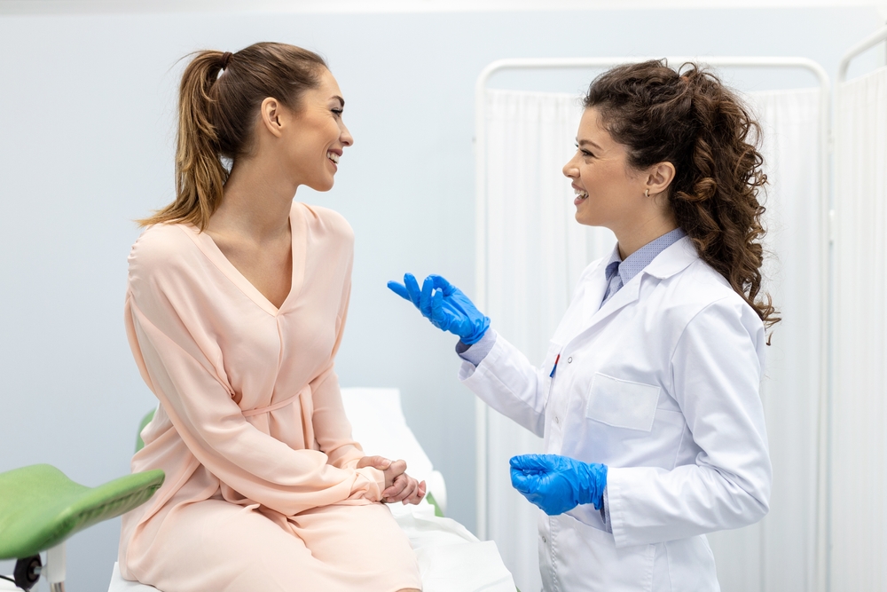 smiling woman talking to female doctor in the office.